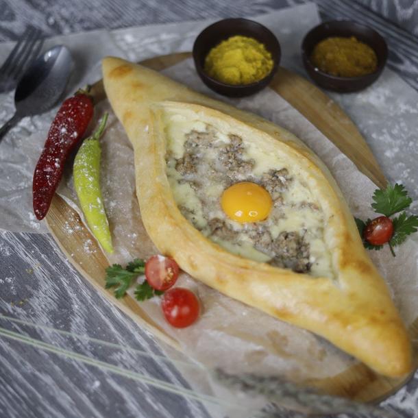 Хачапури по-аджарски (лодочка) с сыром, мясом и яйцом. Хачапури по-аджарски (лодочка) с сыром, мясом и яйцом.